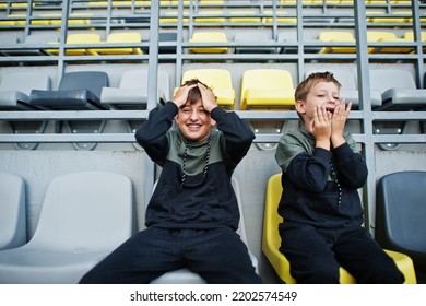 Oh No, They Lost The Game! Two Brothers Support Their Favorite Team, Sitting On The Sports Podium At The Stadium.