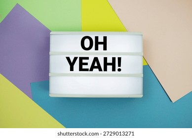 Oh Yeah! text in lightbox flat lay on colorful pastel background