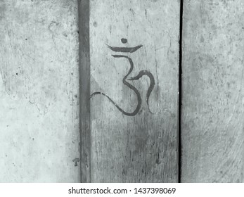 Ohm signal of Hindi language is written on a wooden window in grey color.