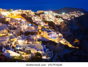 Oia town aerial panoramic view on sunset. Oia or Ia is a small town on Santorini island in the Cyclades, Greece.