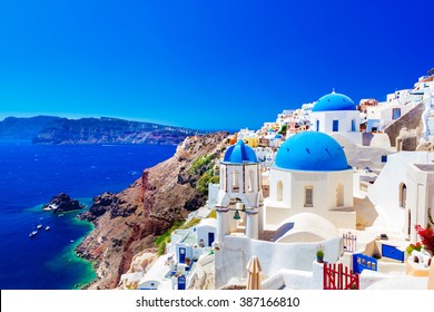 Oia town on Santorini island, Greece. Traditional and famous houses and churches with blue domes over the Caldera, Aegean sea - Shutterstock ID 387166810