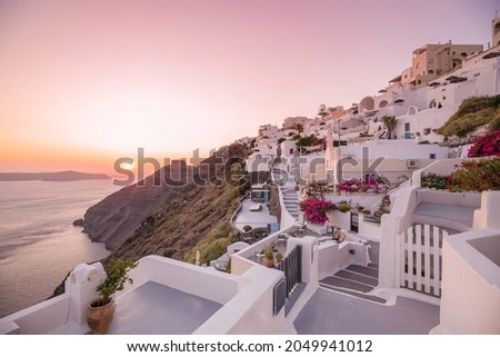 Oia village at night, Santorini island. Famous travel landscape, luxury vacation destination scenic. Beautiful view of fabulous picturesque village colorful sky, traditional white houses, romantic