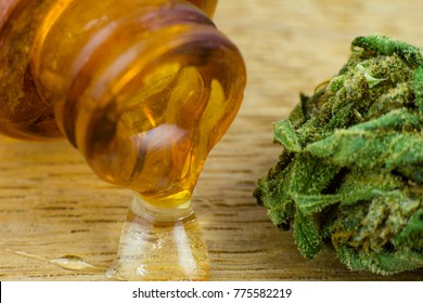 Oil of Cannabis - Medical marijuana and resin oil in apothecary old bootle on the oak wood background.
