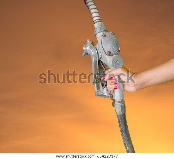 Oil dispenser handle,Woman hand catch oil\
dispenser Orange background