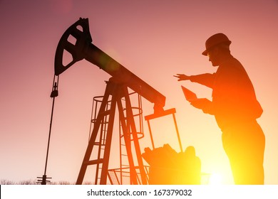 Oil Drill, Field Pump Jack Silhouette With Setting Sun And Worker.Refinery, Natural Gas. Lens Flare. See More Images And Video From This Series 