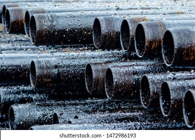 Oil Drill pipe. Rusty drill pipes were drilled in the well section. Downhole drilling rig. Laying the pipe on the deck. View of the shell of drill pipes laid in courtyard of the oil and gas warehouse.