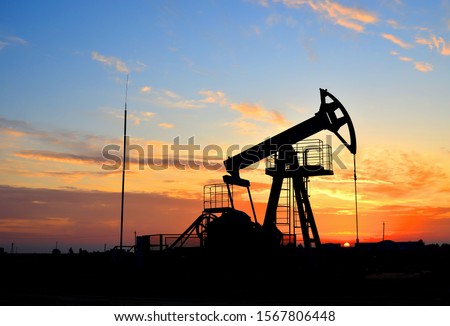 Oil drilling derricks at desert oilfield for fossil fuels output and crude oil production from the ground. Oil drill rig and pump jack background, texture. Belarus, Rechitsa region