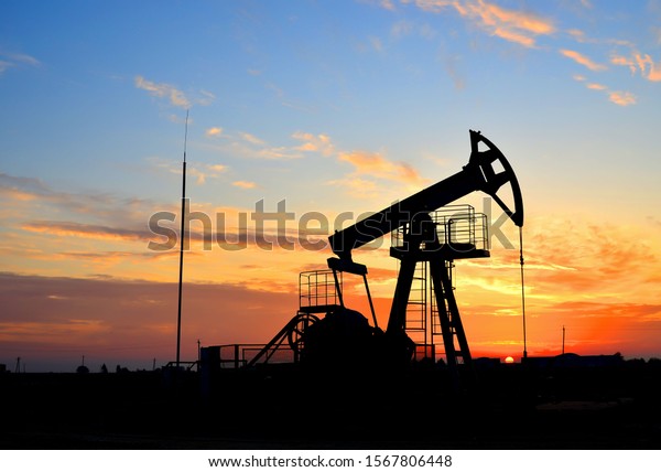 Oil\
drilling derricks at desert oilfield for fossil fuels output and\
crude oil production from the ground. Oil drill rig and pump jack\
background, texture. Belarus, Rechitsa\
region