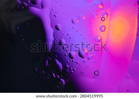 oil drops and bubbles create an abstract pattern in purple, pink, and orange fluid