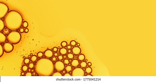 Oil Drops With Bubbles On Yellow Background. Cosmetic Oil Serum Detail. Abstract Orange Color Liquid Texture Macro