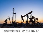 Oil field, oil drilling rig in the evening
