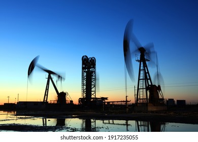 Ölfeld, am Abend, Ölpumpen laufen, Silhouette der Strahlpumpen