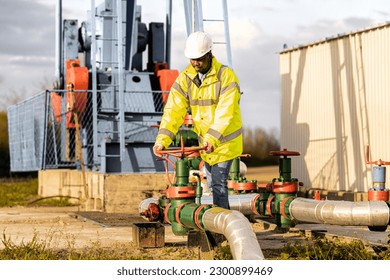 Oil field worker checking pipeline pressure of an oil rig.