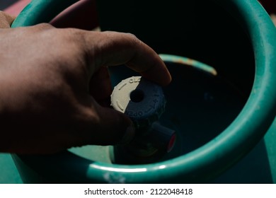 Oil Field Worker Opening The Valve Of A Propane  Gas Cylinder Without Proper Safety .