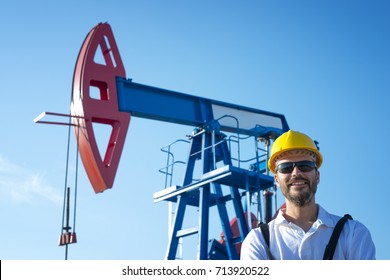 Oil Field Worker Standing In Front Of The Oil Pump. Oil Rig And Industry Concept. 