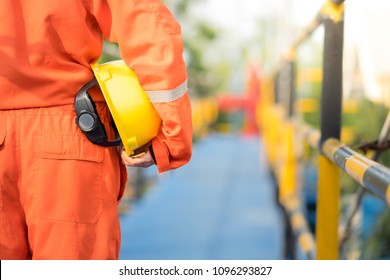 Oil Field Worker, Technician, Operator With Safety Helmet On The Platform Walk Way Before The Sun Set Time.