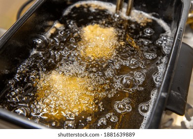 A Oil Frier With Food And Chicken Cooking In The Frier