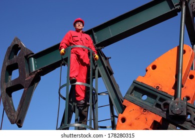 Oil And Gas Industry. Pump Jack Maintenance And Repair. Worker In Action At Pump Jack Oil Well. 