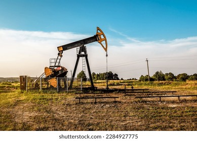 Oil and gas industry. Working oil pump jack on oil field at sunset. Industrial theme - Powered by Shutterstock