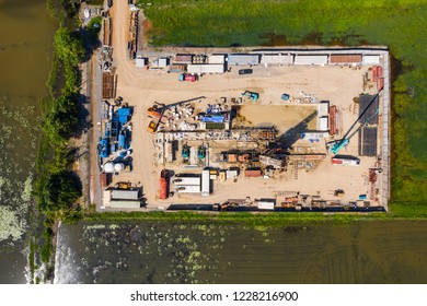 Oil And Gas Land Drilling Rig Onshore In The Middle Of A Rice Field Aerial View From A Drone