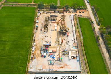 Oil And Gas Land Drilling Rig Onshore In The Middle Of A Rice Field Aerial View From A Drone