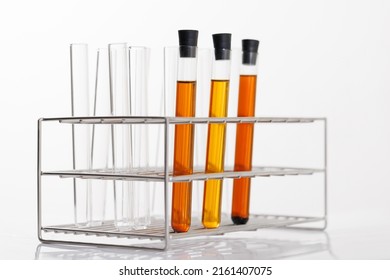 Oil In Glass Tubes In Stainless Rack On White Background. Oil Testing In Industry Labratory.