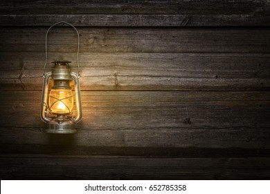 Oil lamp at night on a wooden wall - Powered by Shutterstock