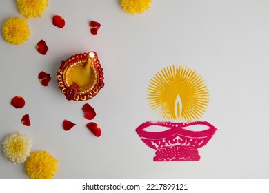 Oil lamps lit during diwali celebration with flowers on white background - Shutterstock ID 2217899121
