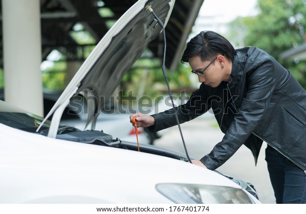 man checking oil\
level in a car, change oil\
car\
