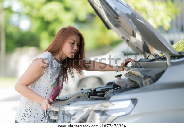 woman checking oil\
level in a car, change oil\
car\
