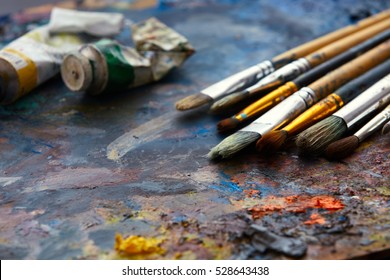 Oil paints and paint brushes on a palette close up. - Powered by Shutterstock