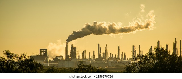 Oil petroleum refinery pollution smoke stack pouring carbon smog into the atmosphere climate change and global warming - Shutterstock ID 1159579726