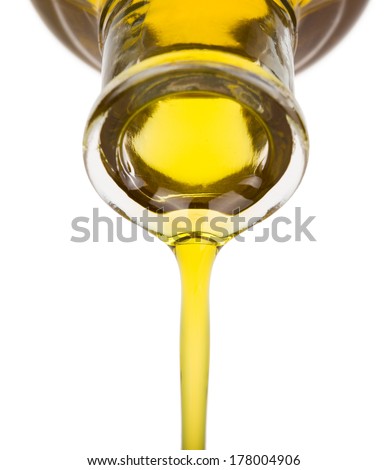 Oil pouring from a bottle isolated on white.