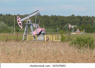 Oil pump. Oil industry equipment in the middle of the field on a background of nature