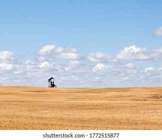 Oil Pump Jack In Golden Field In The Prairies Of Alberta