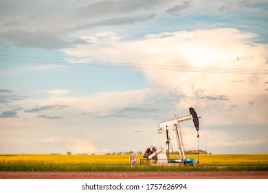 Oil Pump Jack In Prairie Canola Field At Sunset | Saskatchewan, Canada