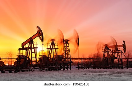 oil pumps at sunset sky background