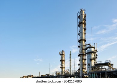 Oil refinery chemical plant wide view with copyspace over blue evening sky with clouds background. Methanol production distillation refinery columns industrial background with copyspace. - Shutterstock ID 2042167880