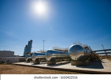 Oil Refinery And Gas Processing Plant In Desert. Four Heat Exchangers And Distillation Towers (refinery Columns) On Blue Sky With Sun. Zhanazhol Oil Deposit, Kazakhstan.