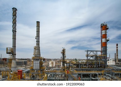 Oil Refinery Plant In Desert. Distillation Towers And Chimneys. Blue Sky With Clouds Background. Panorama View.