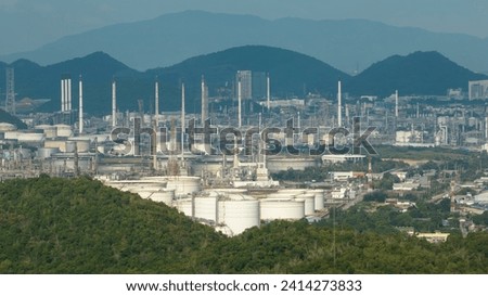 Oil refinery plant industry factory zone, oil and gas petrochemical industrial, oil storage tank and pipeline steel on island mountain background, aerial view