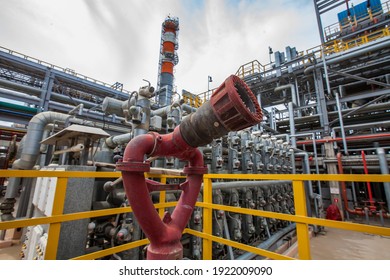 Oil Refinery Plant Safety Technologies. Fire Extinguisher  Distillation Tower And Pipelines On Background.