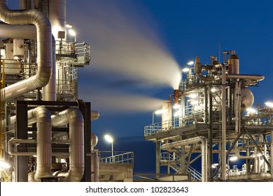 Oil refinery with water vapor in Hamburg, Germany, petrochemical industry night scene