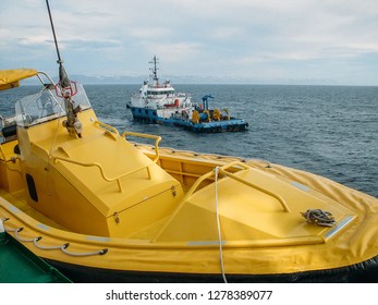 Oil Research And Exploration Seismic Vessel Or Ship In Sea And Yellow Boat At Another Ship On Foreground