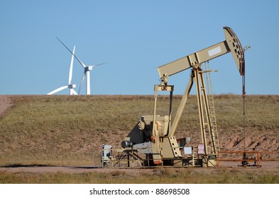 Oil Rig Pump Jack With Wind Turbines In Background