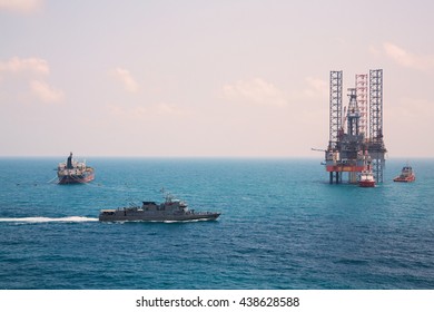 Oil Rig And Oil Tanker Ship With Patrol Vessel Sailing Pass In The Gulf