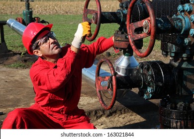 Oil Rig Worker. Oil and gas industry.  Oil worker turning valve on oil rig. 