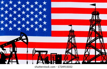 Oil Rigs On The Background Of The American Flag. America's Oil Industry. The Export Of American Oil. Global Energy Market. Natural Resource Extraction In The United States. Fuel Industry Of The US.