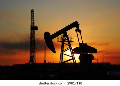 oil rigs silhouette over orange sky
