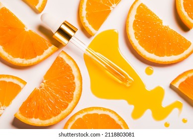 Oil Serum Vitamin C Anti Aging Antioxidant Beauty Care Product Dropper On White Background And Slice Of Orange Fruit Natural Organic Cosmetic Concept.